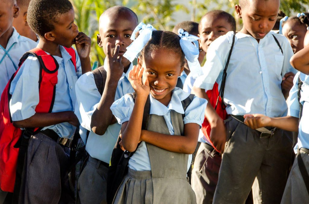 kinderen uit Haïti zeggen hallo in hun school uniform